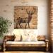 This is a large rustic wood wall hanging featuring an outline of  deer with antlers, a forest scene is shown within the deer silhoette.